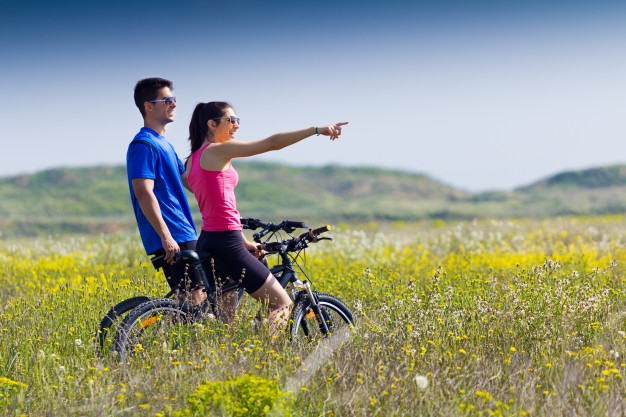 happy-young-couple-bike-ride-countryside_1301-6095