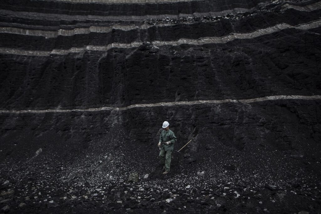 A PPC worker collects a sample from the coal for f