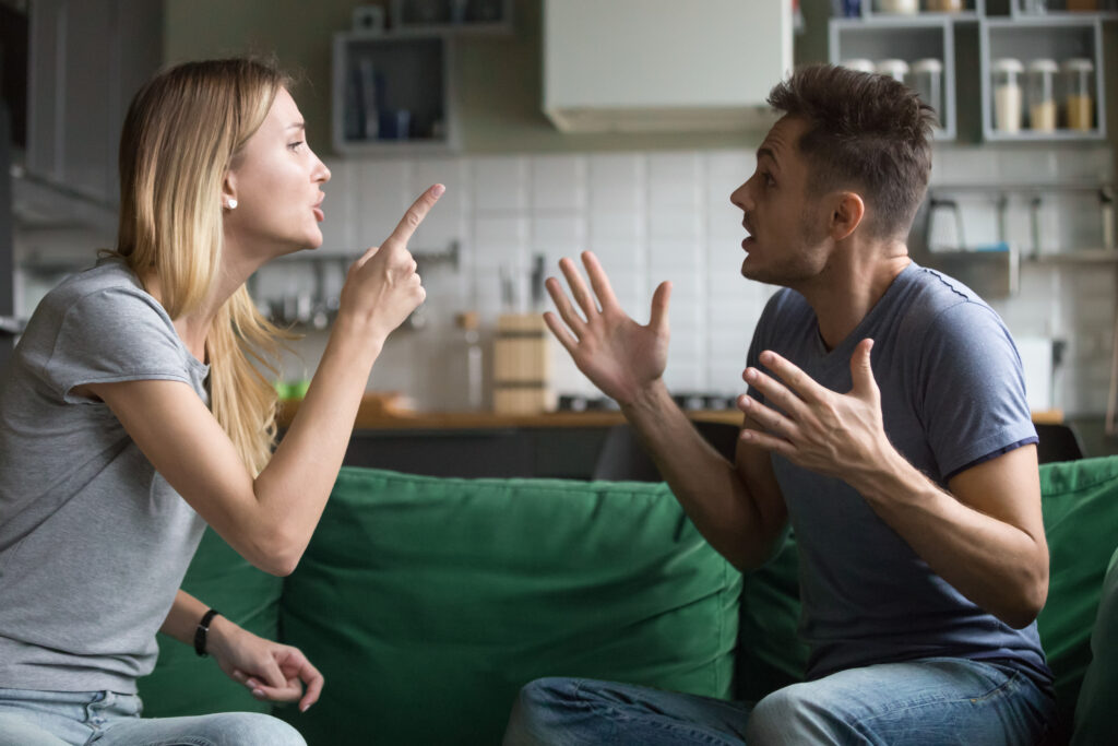 Angry millennial couple arguing shouting blaming e