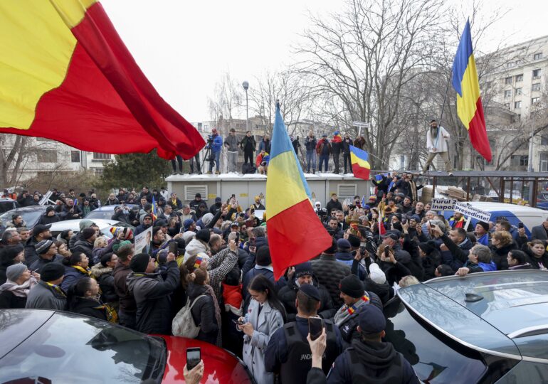 Susținătorii lui Georgescu au venit în fața Parchetului și strigă „Jos dictatura” și „Ultima soluție, încă o revoluție”. Cristela e printre ei. Bodyguardul acesteia avea o armă de foc neletală (Foto & Video)