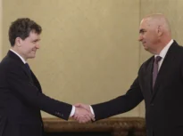 Palatul Cotroceni, consultări politice, 18 mai 2025. Președintele Nicușor Dan dă mâna cu Ilie Bolojan, premierul interimar și liderul PNL. Amândoi zâmbesc enigmatic, fără urmă de ostilitate, orice ar însemna acest lucru
