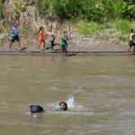 Jumătate dintre copiii lumii sunt expuși simultan la mai multe pericole climatice, avertizează UNICEF. Unii trebuie să înoate printre crocodili ca să ajungă la școală